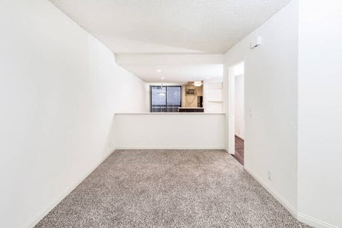 an empty living room with white walls and carpet