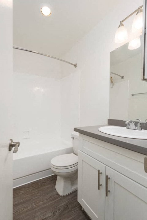 a white bathroom with a toilet and a sink