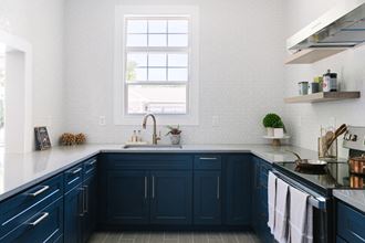 a kitchen with navy blue cabinets and a window