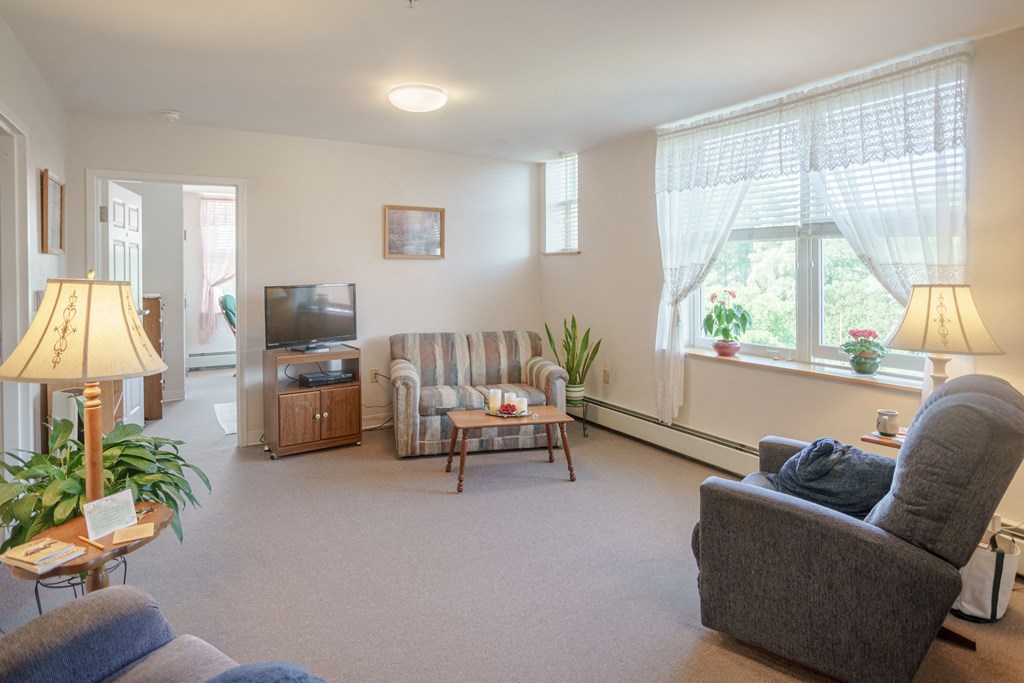 a living room with a couch and a chair and a television