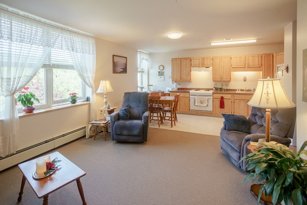 a living room with couches and a kitchen with a table and chairs