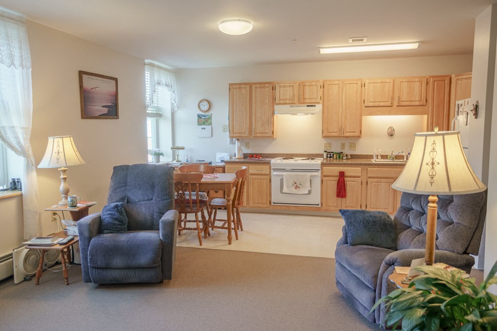 a living room with couches and a kitchen with a table and chairs