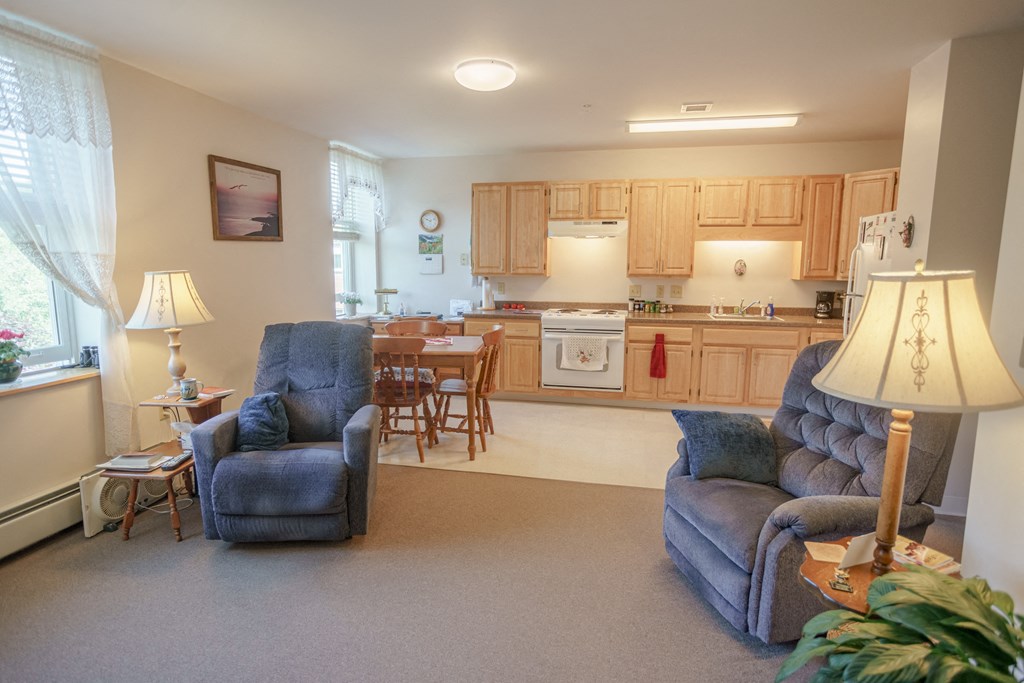 a living room with couches and a kitchen with a table and chairs