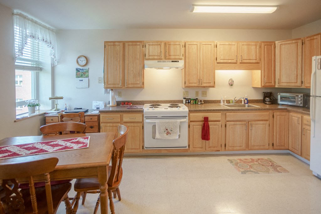 a kitchen with wooden cabinets and a table and chairs