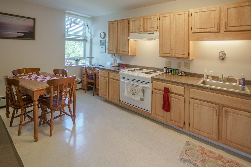 a kitchen with wooden cabinets and a table with chairs