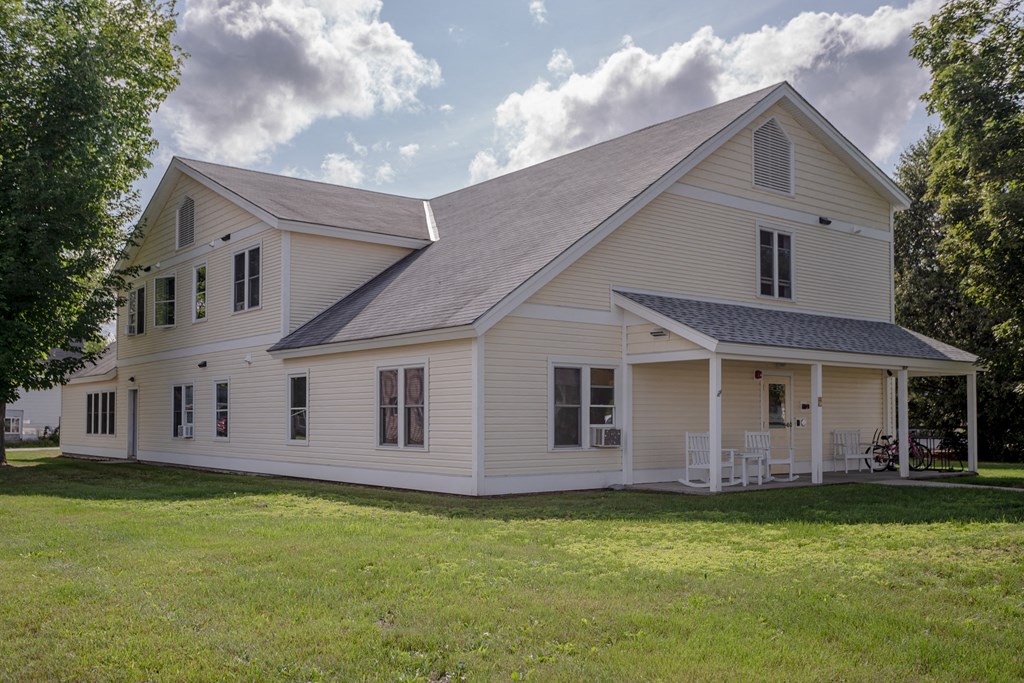 a white house with a porch and a lawn