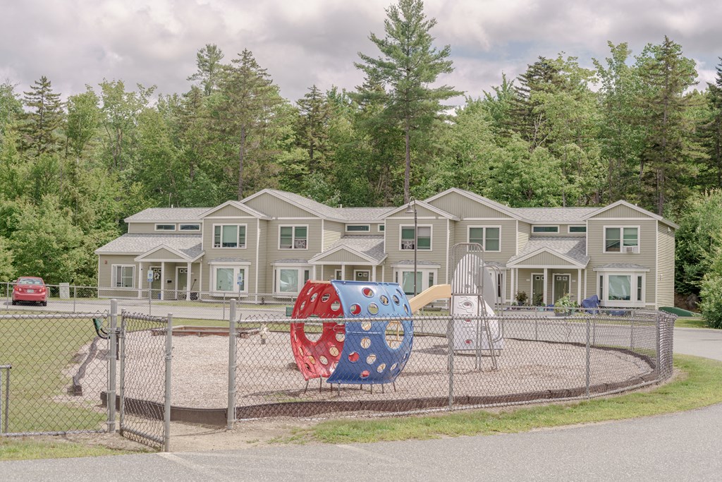 a playground in front of a house with a large orb on it