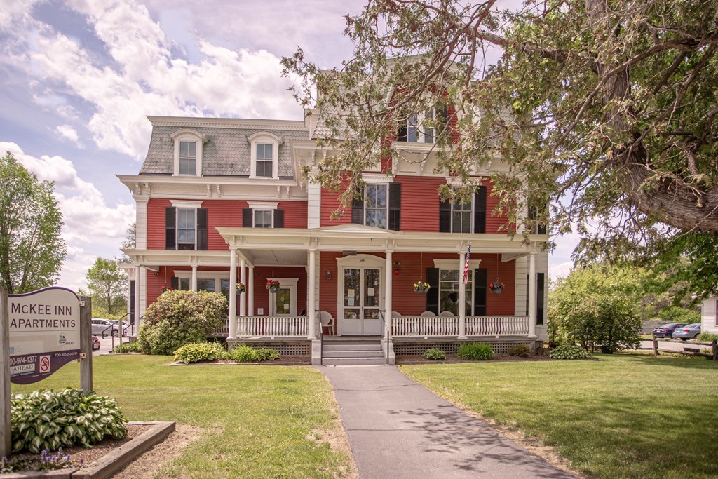 a large red house with a sidewalk in front of it
