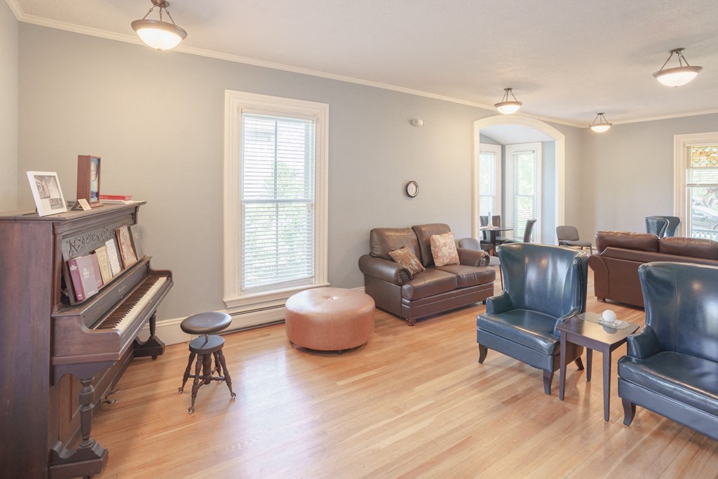 a living room with leather furniture and a piano