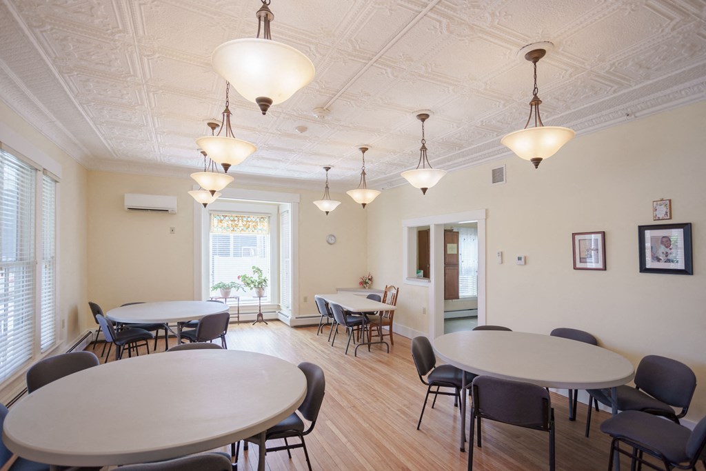 a dining room with tables and chairs and lights on the ceiling