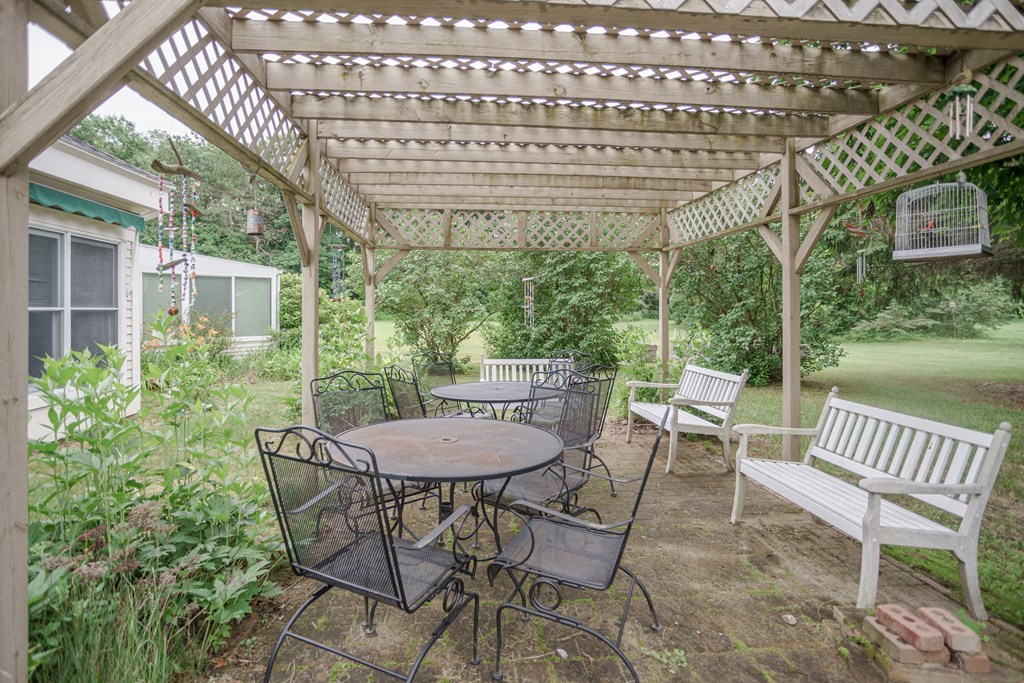 a patio with a pergola and a table and chairs
