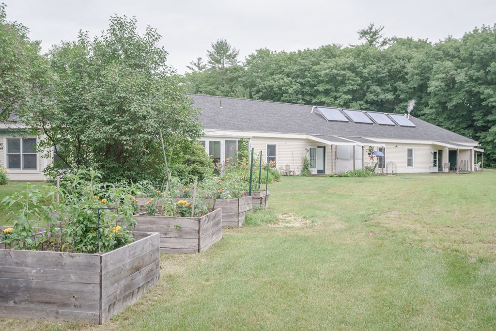 a garden in front of a house with solar panels on the roof