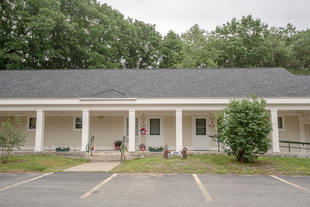 the front of a white house with columns and a porch