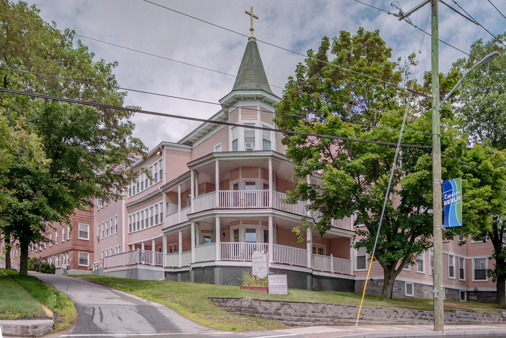 a pink building with a steeple on the corner of a street
