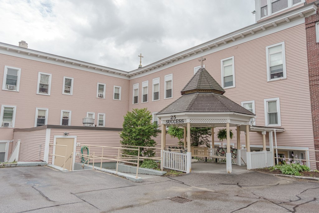 the outside of a pink building with a gazebo