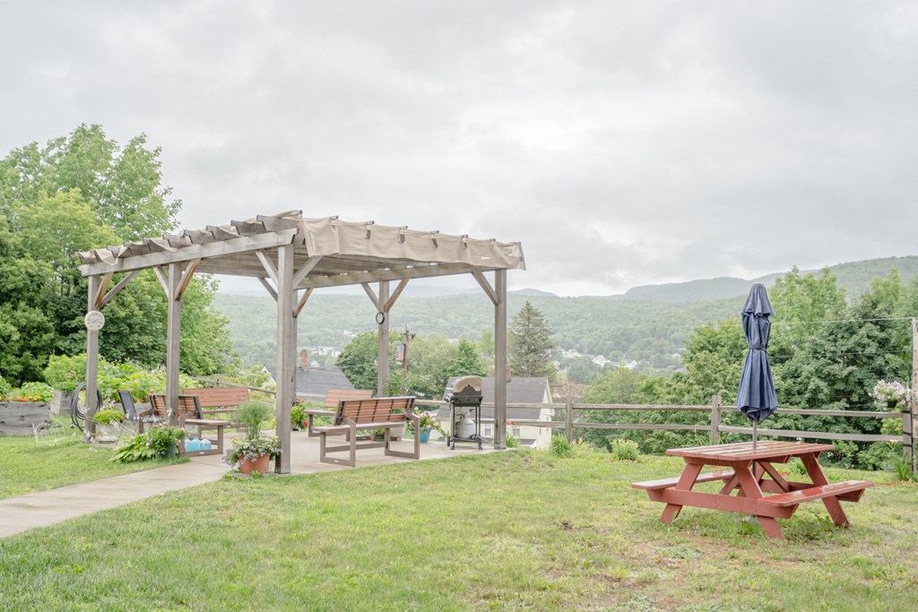 a picnic area with benches and a pergola