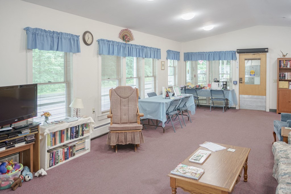 a living room and dining room with a table and chairs and a tv