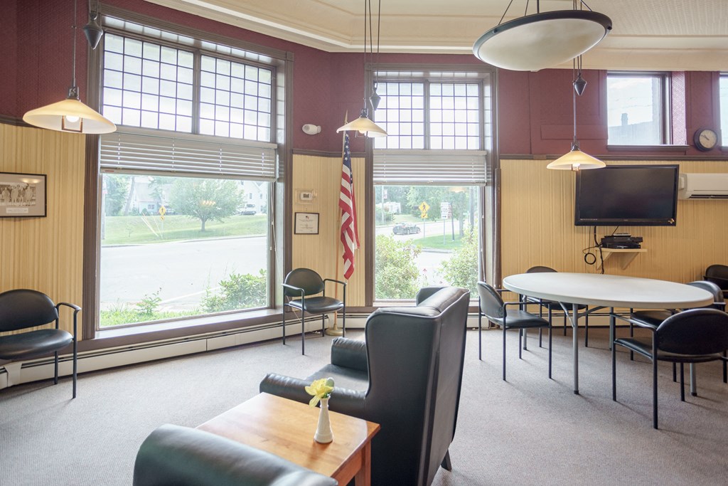 a conference room with chairs and tables and a tv