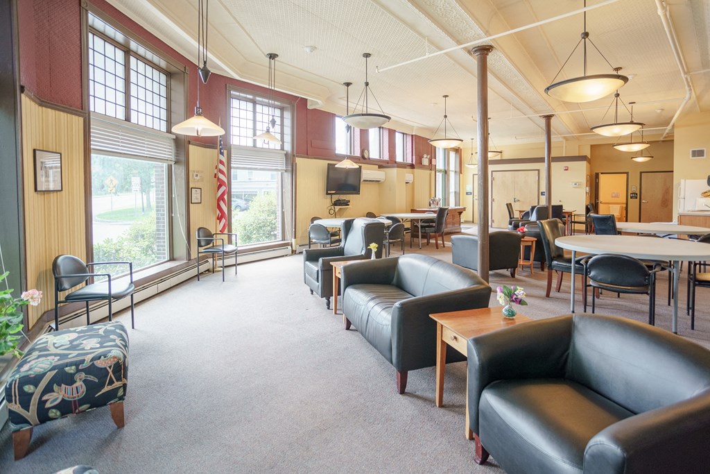 a lounge area with leather couches and tables and chairs