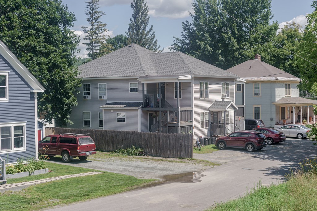 a row of houses with cars parked in front of them