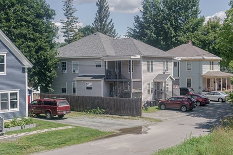 a row of houses with cars parked in front of them