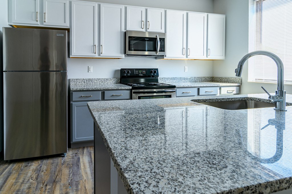 a kitchen with granite counter tops and stainless steel appliances