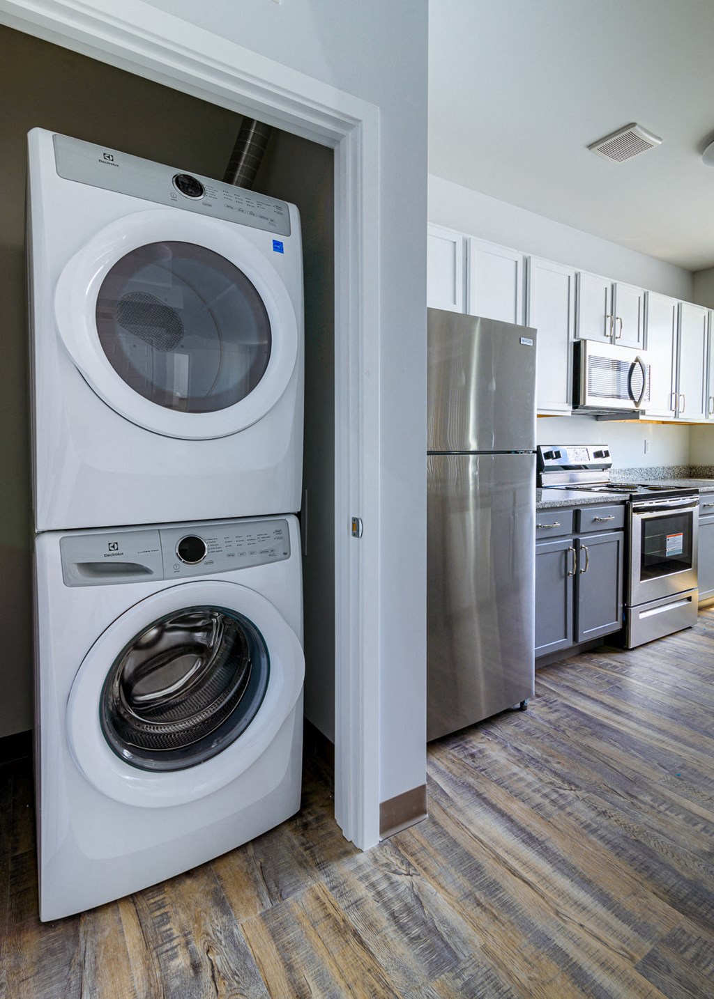 a washer and dryer in a kitchen with a stainless steel refrigerator