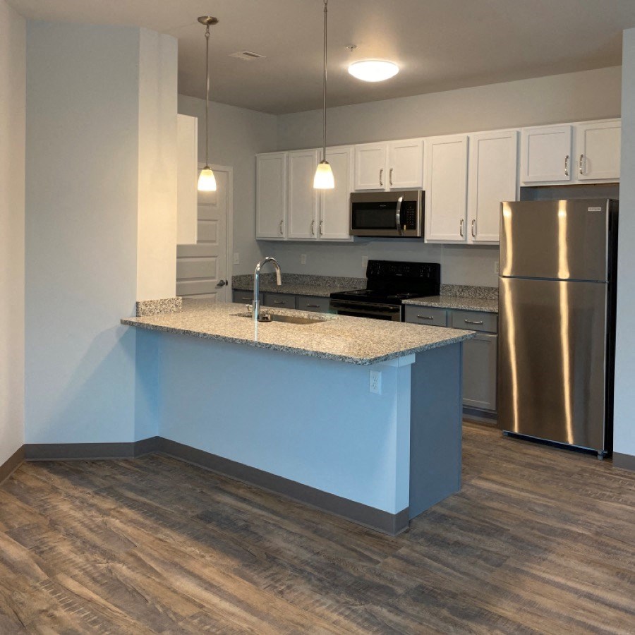 a kitchen with a counter top and a stainless steel refrigerator