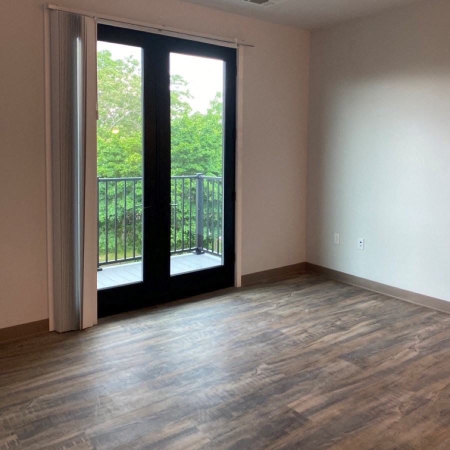 an empty living room with sliding glass doors and a balcony