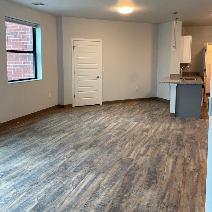 an empty room with a kitchen and a door
