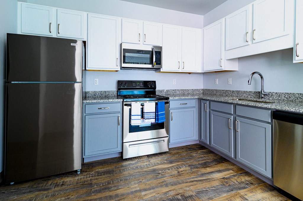 a kitchen with white cabinets and stainless steel appliances
