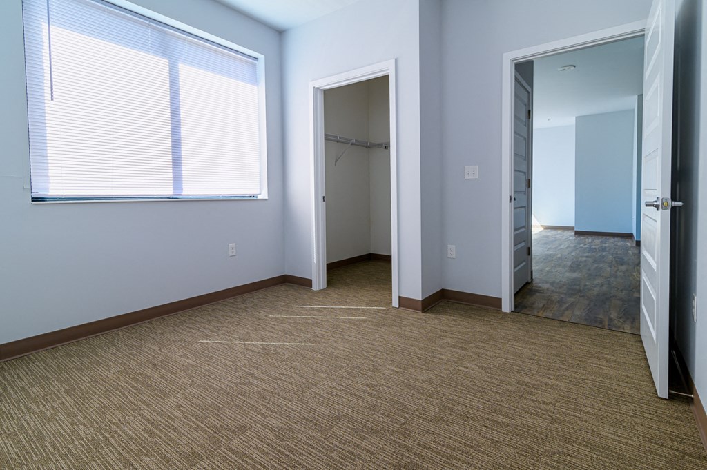 an empty room with a closet and a window