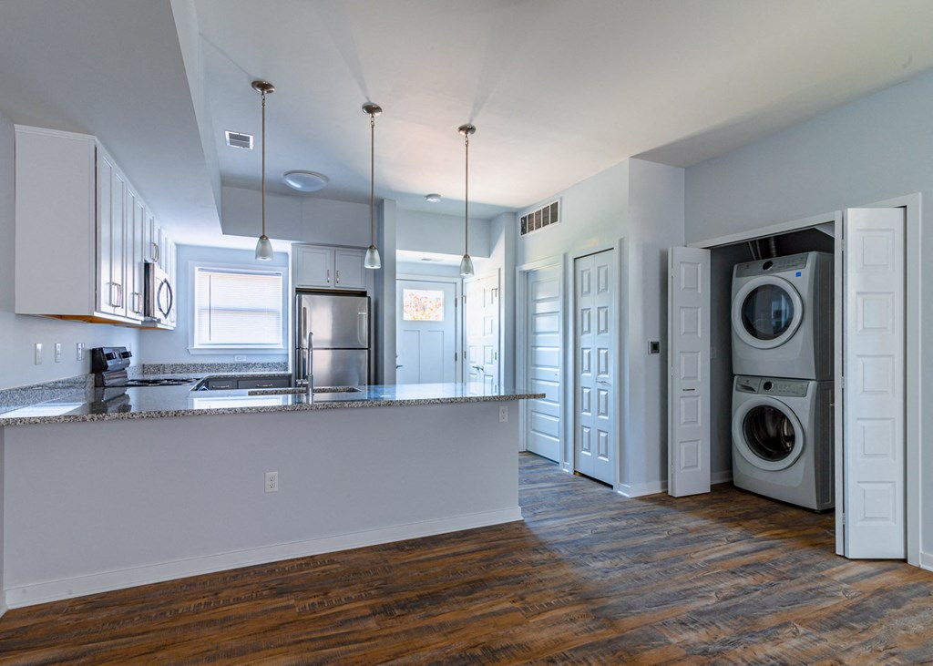 an empty kitchen with a washing machine and a washer and dryer