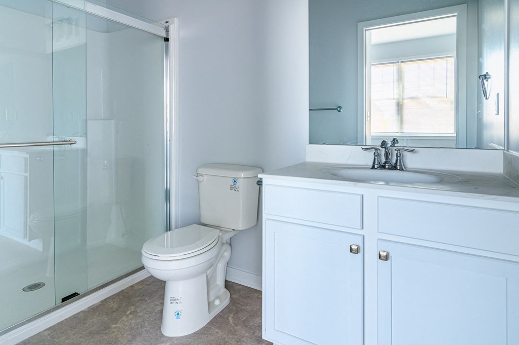 a bathroom with a toilet and a sink and a shower