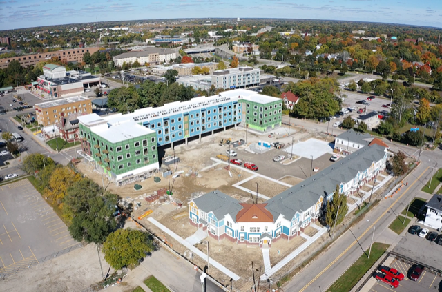 an aerial view of a city with a blue building and white and green buildings