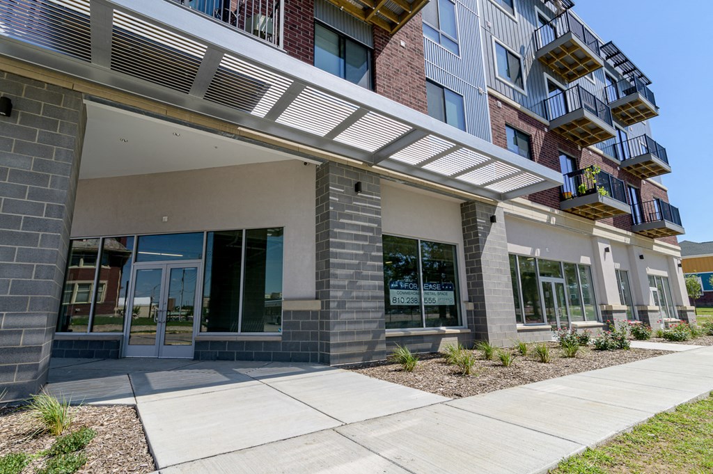 an exterior view of a building with glass doors and a sidewalk