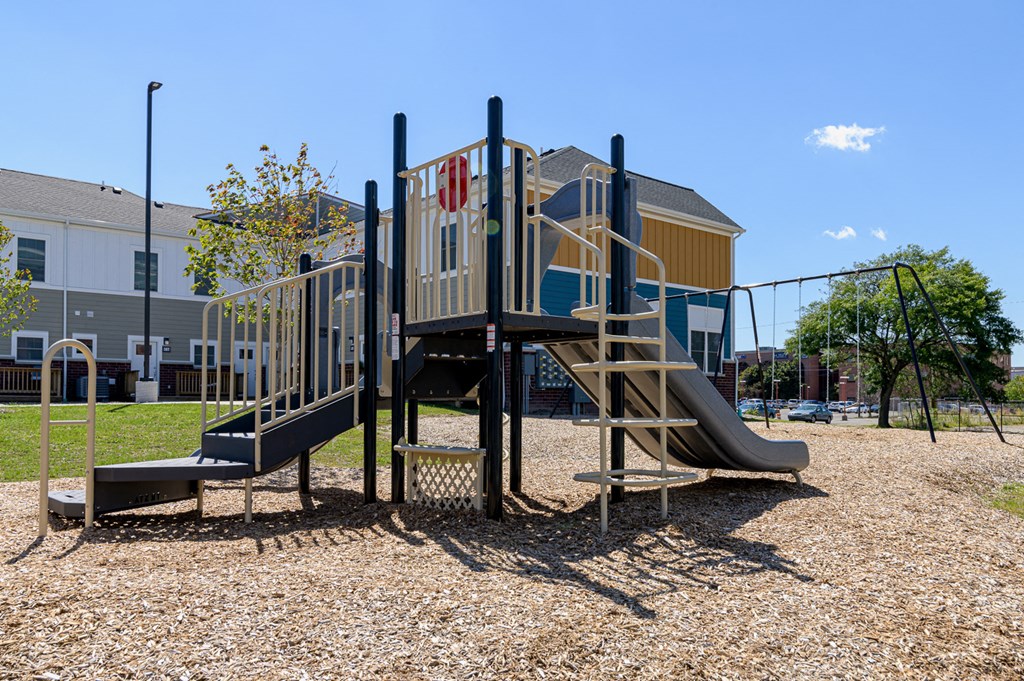 a playground with a set of slides in front of a building