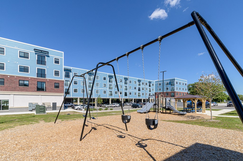 a swing set in a playground in front of a building