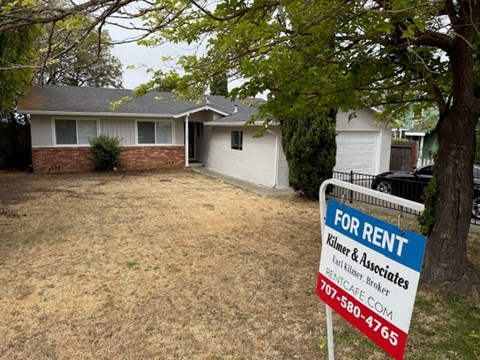 A house is for rent and the sign is white and red.
