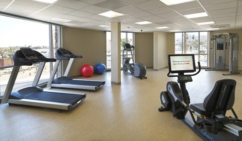 a gym with weights and other exercise equipment in a room with a window