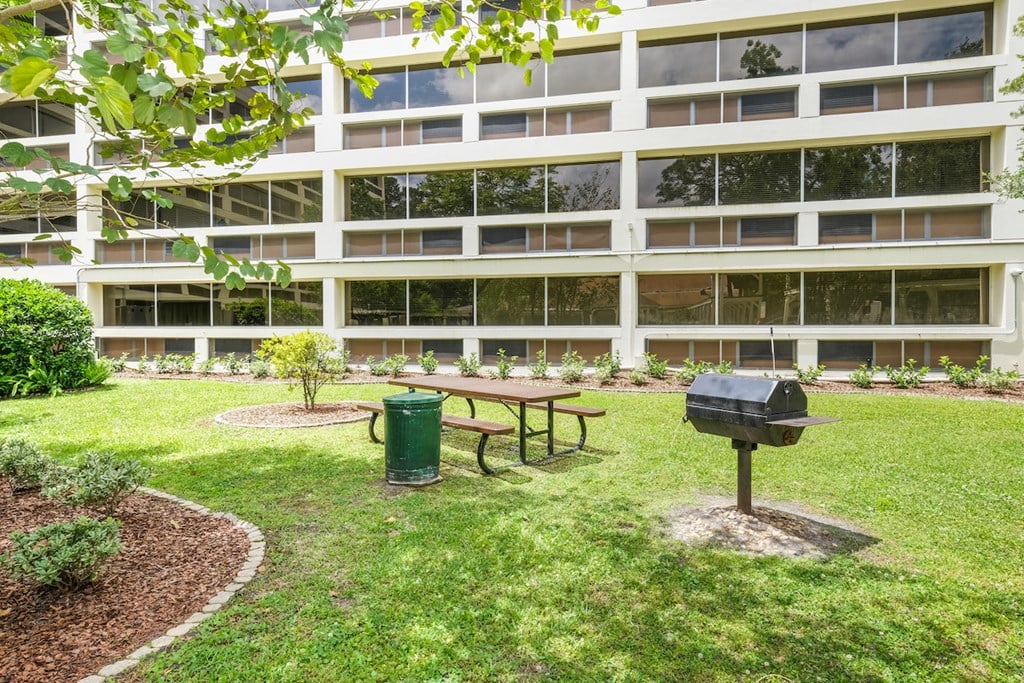 an office building with a courtyard with a picnic table and a grill
