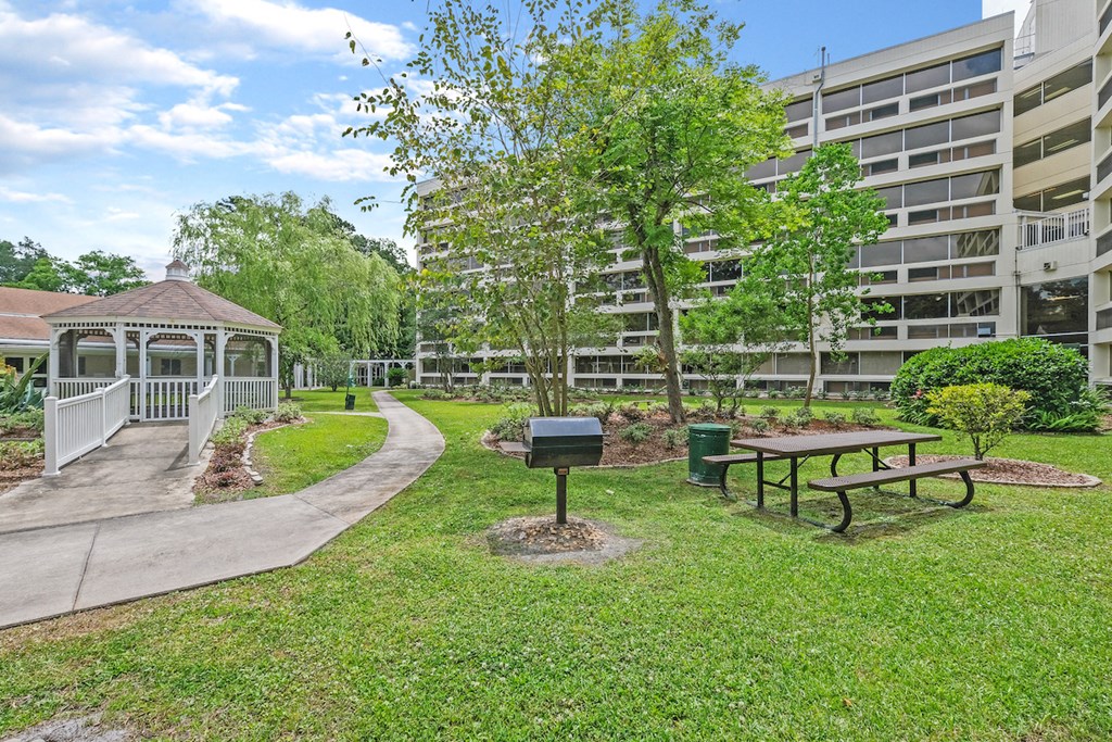 a park with a gazebo and picnic table next to an apartment building