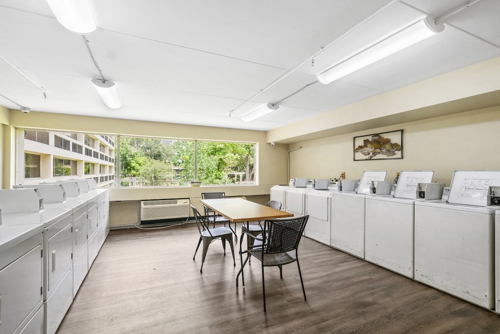 a room with laundry facilities and a table with chairs