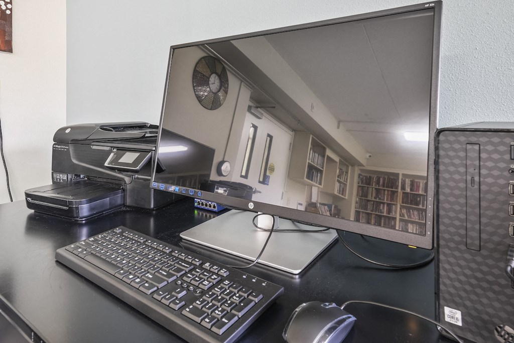 an office desk with a computer monitor and keyboard and mouse