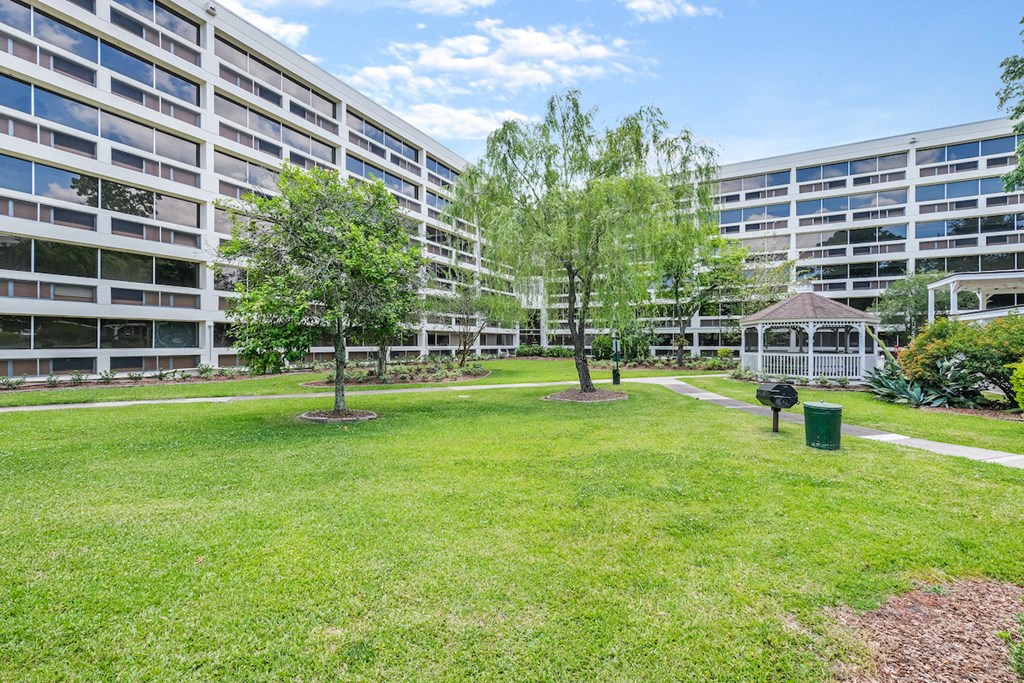 a park with a gazebo in front of an apartment building