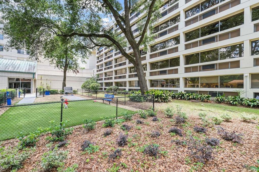 a park with a tennis court in front of an apartment building