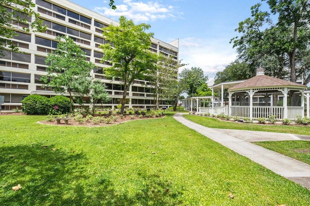 a park with a gazebo in front of an apartment building