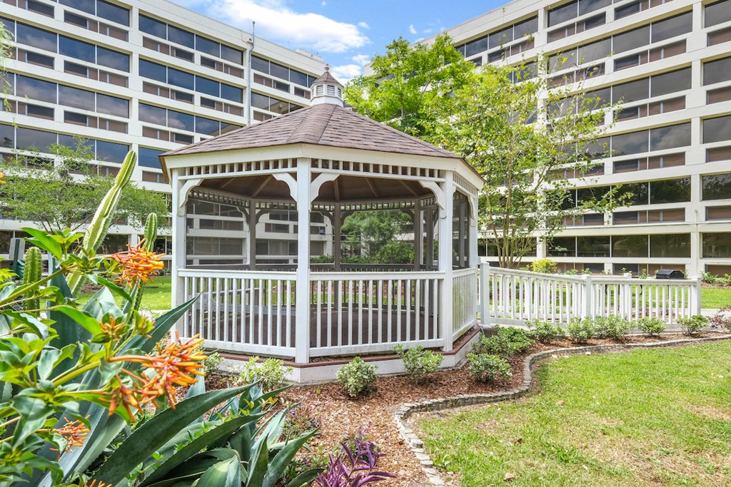 a gazebo in a garden in front of a building