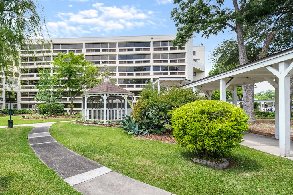 a garden with a gazebo in front of an apartment building