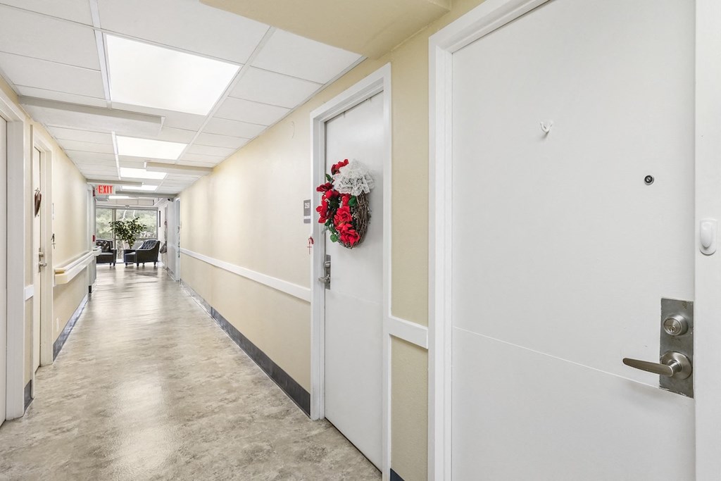 a hallway with white doors and white walls and a wreath on the door